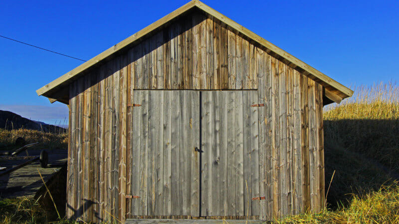 A frontside shot of a wooden boat storage hut in Grense Jakobselv.