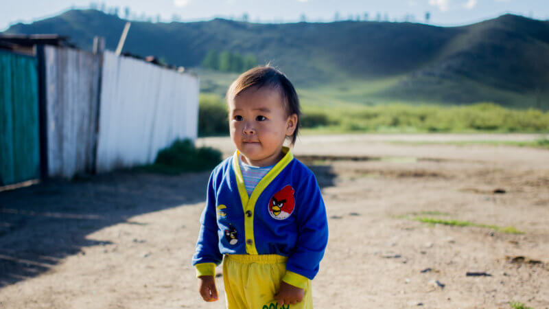 A little Tuvan boy with yellow shirts and blue sweater.
