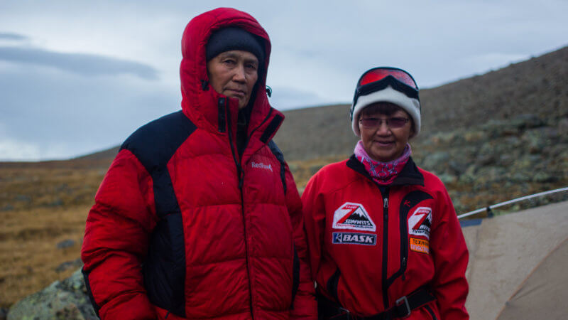 Two Tuvan mountaineers in red clothing at their campsite near Munghulik.