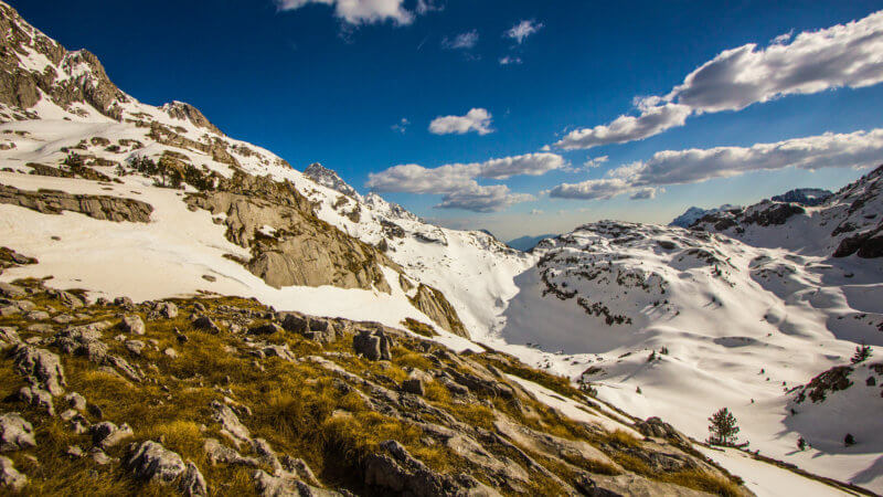 Wide angle shot of a limestone plateau with deep snow covered bowls.