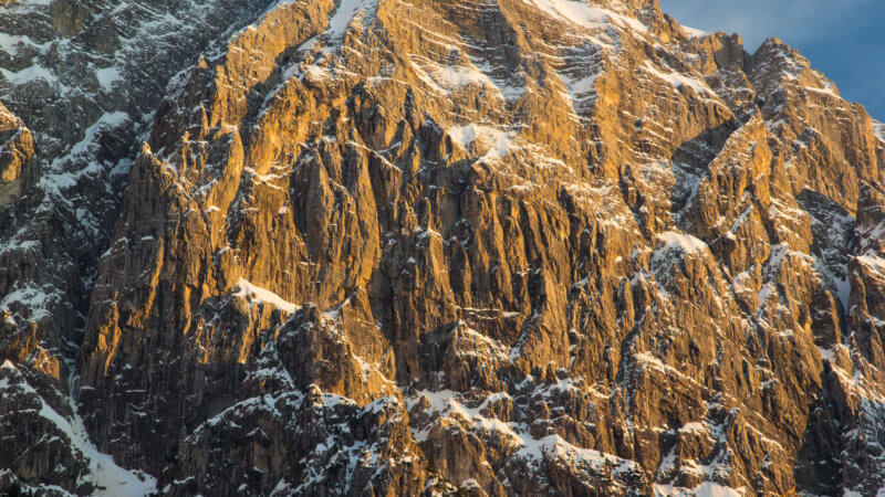 Close up photo of jagged limestone mountains dusted in powder snow.